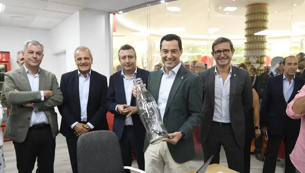 El presidente de la Junta de Andalucía, Juanma Moreno, firma una botella en conmemoración del XXV aniversario de la fábrica en Sevilla