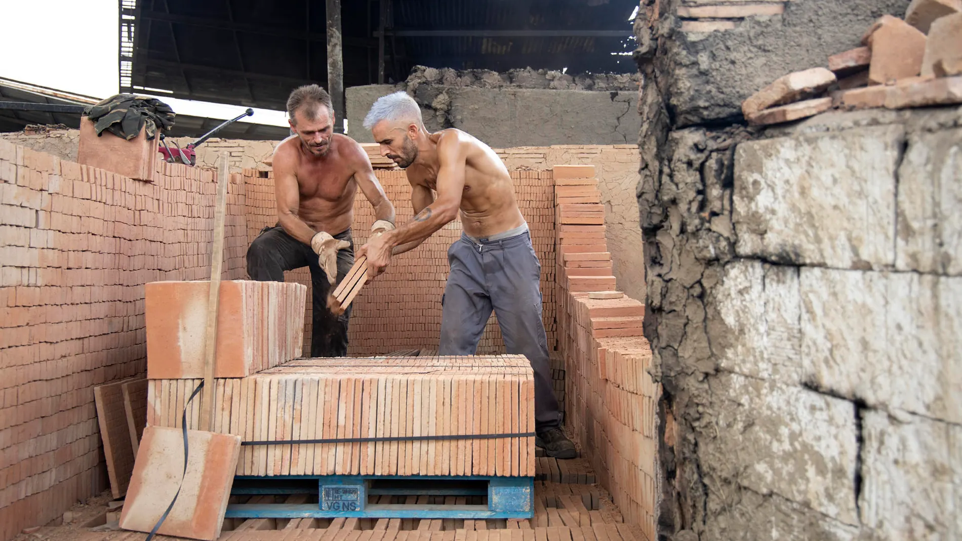 Dos operarios trabajan en el horno árabe del tejar de los hermanos Lobillo en Vélez-Málaga