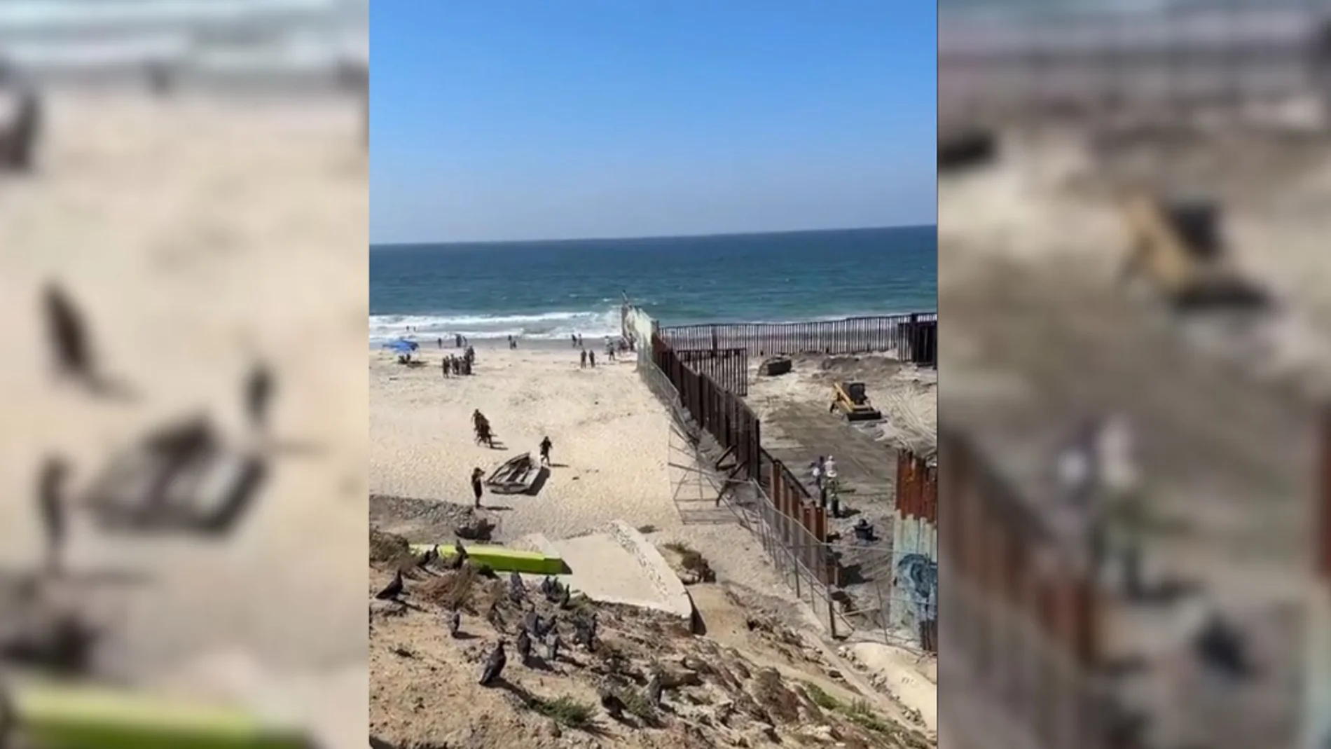 Mexicanos cruzando el muro fronterizo entre México y Estados Unidos