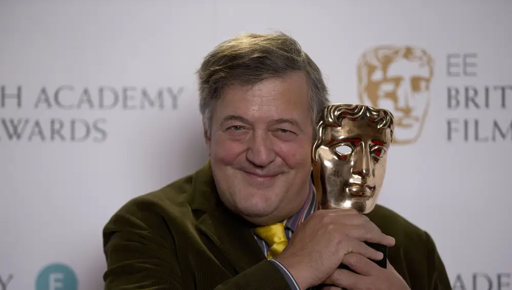 British comedian and actor Stephen Fry poses for photographs with a BAFTA (British Academy of Film and Television Arts) statuette during a photo call to mark the announcement of the BAFTA award nominations in London, Friday, Jan. 9, 2015. Fry will be the host of the ceremony on Feb. 8 at the Royal Opera House in London and announced the nominations Friday with British actor Sam Claflin. (AP Photo/Matt Dunham)