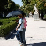 Dos turistas se protegen del sol y del intenso calor el pasado viernes 29 de septiembre en Madrid