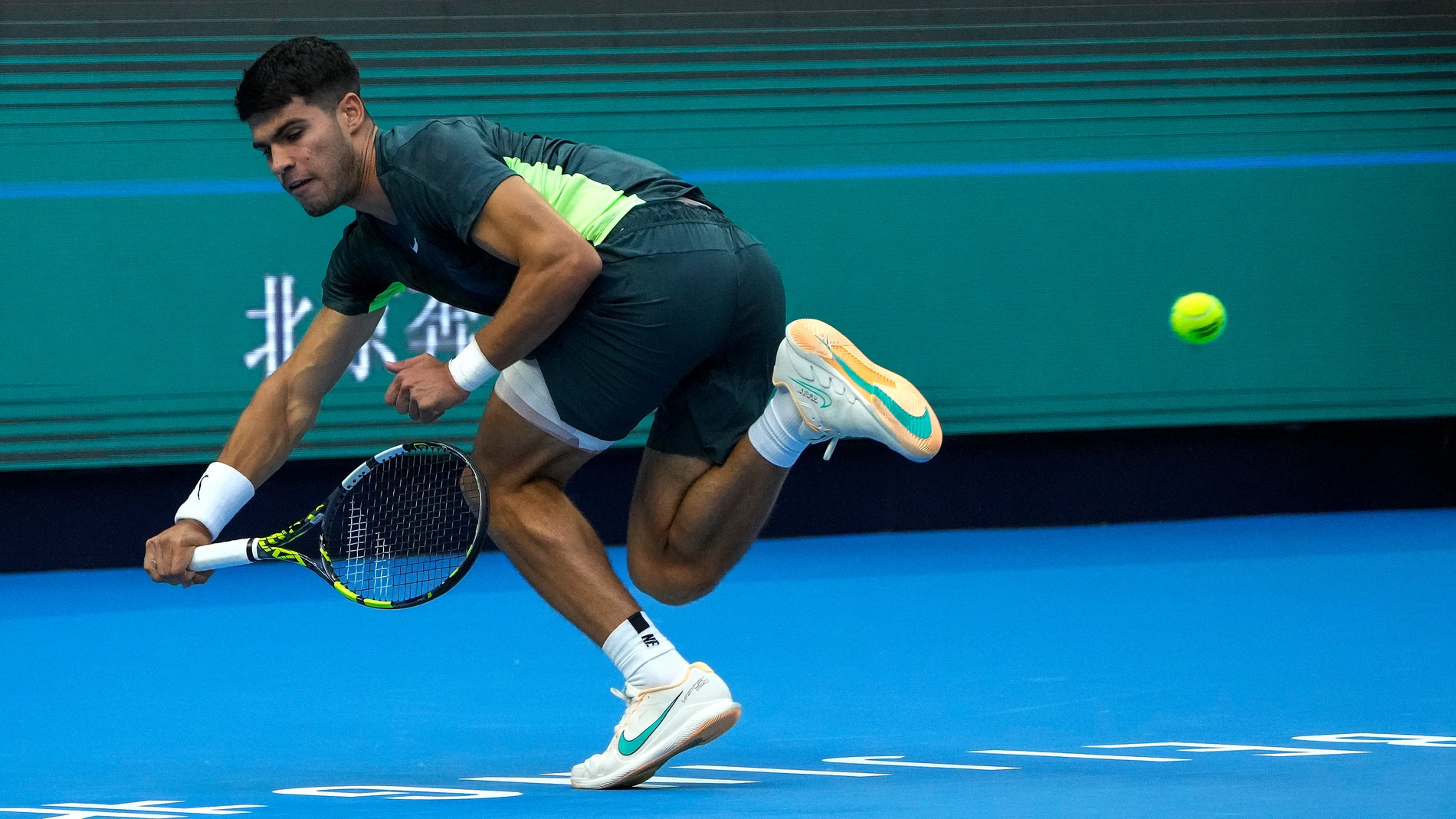 Carlos Alcaraz of Spain hits a backhand shot against Lorenzo Musetti of Italy during the second round of the men's singles in the China Open tennis tournament at the Diamond Court in Beijing, Sunday, Oct. 1, 2023. (AP Photo/Andy Wong)