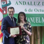 Juanma Moreno recibe de la mano de la presidenta de la Casa de Andalucía Paquita Marín el reconocimiento 'Andaluz del Año 2023