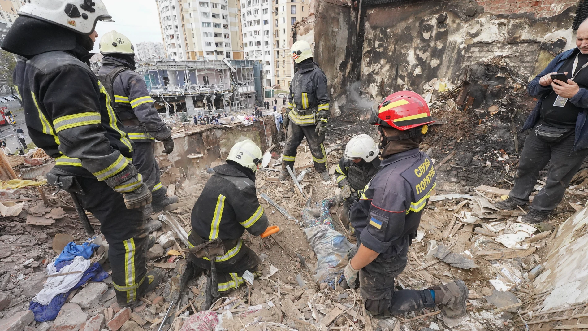 Emergency workers recover the body of a 10-year old boy who was killed in a Russian air attack that hit a multi-storey building in central Kharkiv, Friday, Oct. 6, 2023. (AP Photo/Andriy Mariyenko)