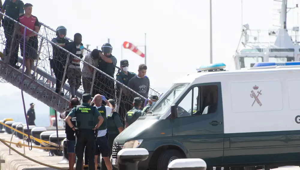 La Guardia Civil ha detenido con cargos de piratería a nueve de los inmigrantes a los que se acusa de haberse amotinado y amenazado con cuchillos a los marineros del remolcador de Países Bajos que los había rescatado de dos pateras en el Atlántico, a unos 105 kilómetros al este de Lanzarote. En la imagen, desembarco en Puerto del Rosario (Fuerteventura) de los 79 inmigrantes rescatados por el buque Vos Pace, algunos de ellos bajo custodia policial.
