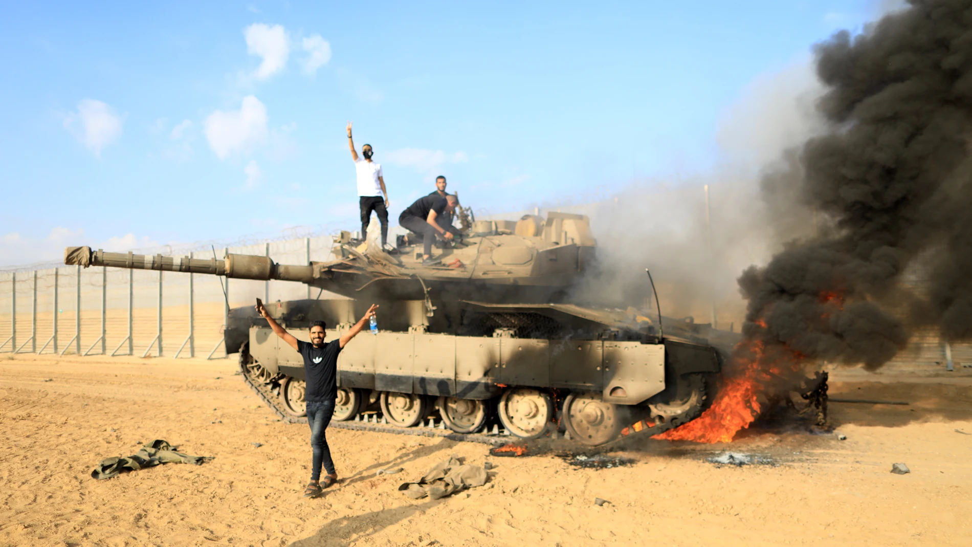 GAZA, Oct. 7, 2023 -- Palestinians are seen near an Israeli tank, near the fence of the Gaza-Israel border, east of the southern Gaza Strip city of Khan Younis, Oct. 7, 2023. TO GO WITH "3rd LD: Massive rockets fired from Gaza into Israel, at least 22 Israelis killed" 07/10/2023