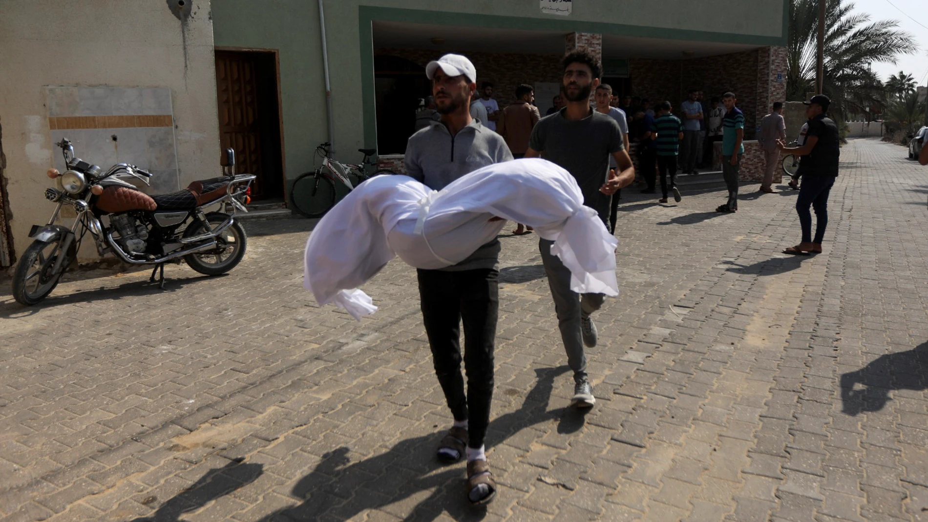 A relative carries a body of the Abu Dagga family who were killed in an Israeli airstrike y during their funeral in Khan Younis, southern Gaza Strip, Saturday, Oct. 7, 2023. (AP Photo/Yousef Masoud)