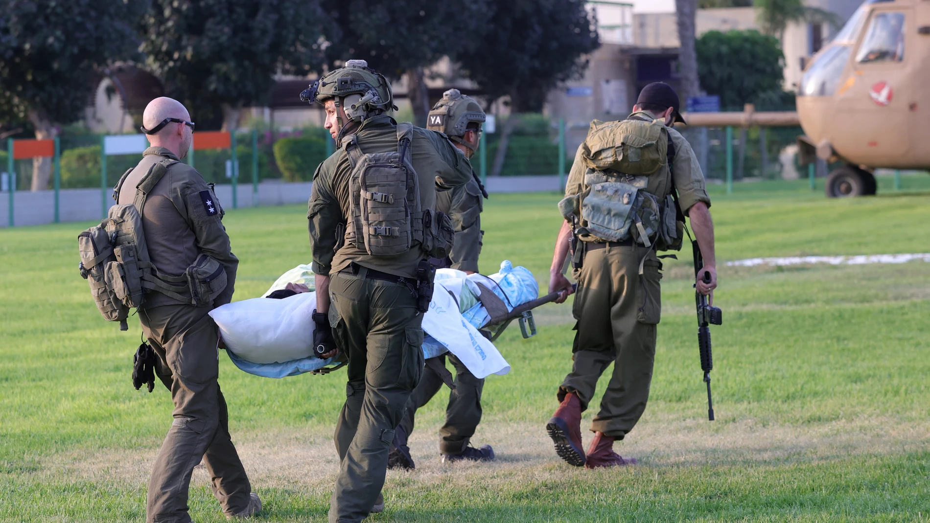 Soldados israelíes y personal médico llevan a toda prisa una camilla con una víctima a un helicóptero de las fuerzas israelíes