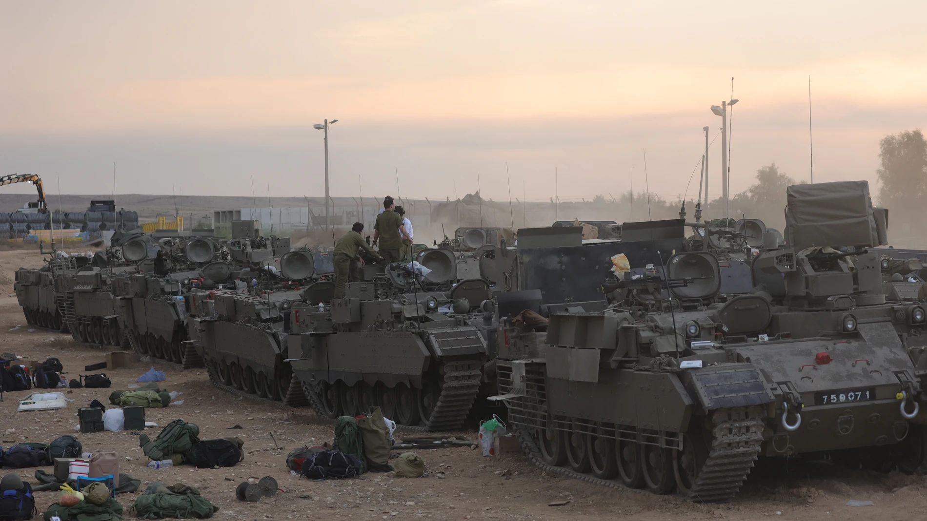 Reservistas israelíes se preparan junto a vehículos blindados de transporte de tropas (APC) en un campamento militar cerca de Beer Sheva, Israel,