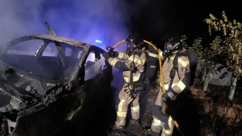 Los bomberos de Ibiza apagan el incendio en el todoterreno negro Land Rover usado este lunes por dos encapuchados para intentar liberar a un preso en Ibiza