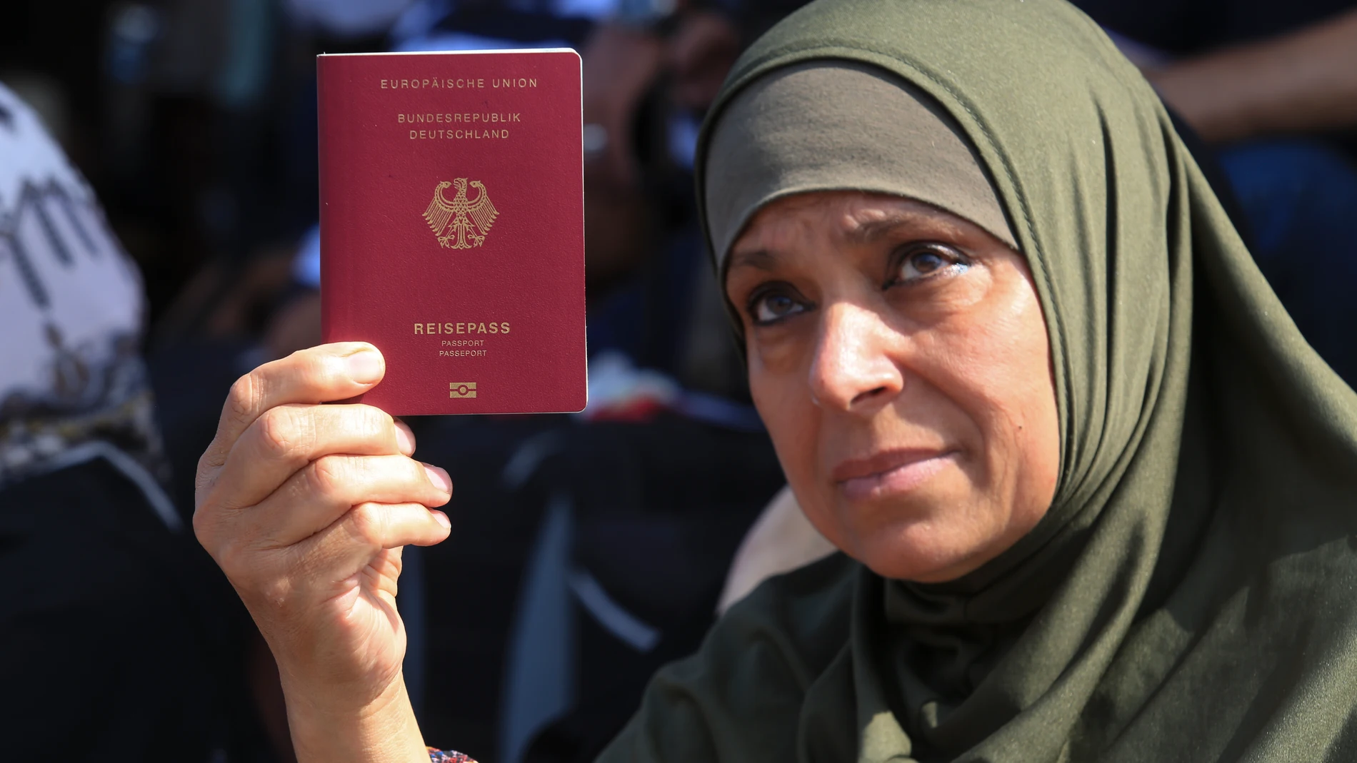 Palestinian woman shows her German passport at the Rafah border crossing between the Gaza Strip and Egypt Gaza Strip on Saturday, Oct. 14, 2023. Israel carried out some limited ground operations ahead of an expected broader land offensive against Gaza's militant Hamas rulers following their attack into southern Israel a week ago. (AP Photo/Hatem Ali)