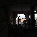 Palestinos inspeccionan los destrozos registrados en un edificio tras el ataque aéreo de tropas israelíes contra la mezquita Al Ansar en el campo de refugiados de Yenín, en Cisjordania, este domingo. 