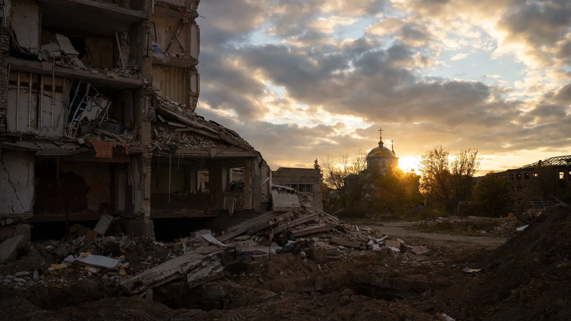 The sun sets over a destroyed building in Izyum, Ukraine, Tuesday, Oct. 24, 2023. (AP Photo/Bram Janssen)