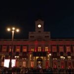 Fachada de la Real Casa de Correos iluminada con la bandera de España