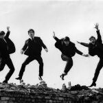 Photo of BEATLES; L-R: Ringo Starr, George Harrison, Paul McCartney, John Lennon - posed, group shot - jumping on wall, Used on the Twist & Shout EP cover 