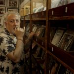 Erik Jiménez, en el documental, reza delante de una estantería de discos