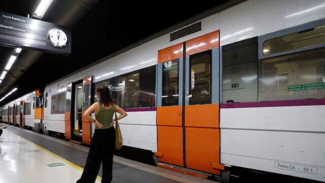 Una mujer espera ante un tren parado durante la huelga de maquinistas convocada por el sindicato Semaf que está provocando una jornada de caos en Rodalies por el "incumplimiento" de los servicios mínimos, que ha supuesto la supresión de más de 80 trenes, el cierre puntual de algunas estaciones y la interrupción de la circulación en la estación de Sants. 