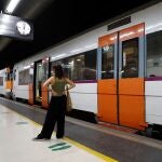 Una mujer espera ante un tren parado durante la huelga de maquinistas convocada por el sindicato Semaf que está provocando una jornada de caos en Rodalies por el "incumplimiento" de los servicios mínimos, que ha supuesto la supresión de más de 80 trenes, el cierre puntual de algunas estaciones y la interrupción de la circulación en la estación de Sants. 