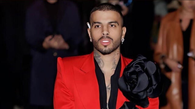 Rauw Alejandro con traje rojo y maxi flores.