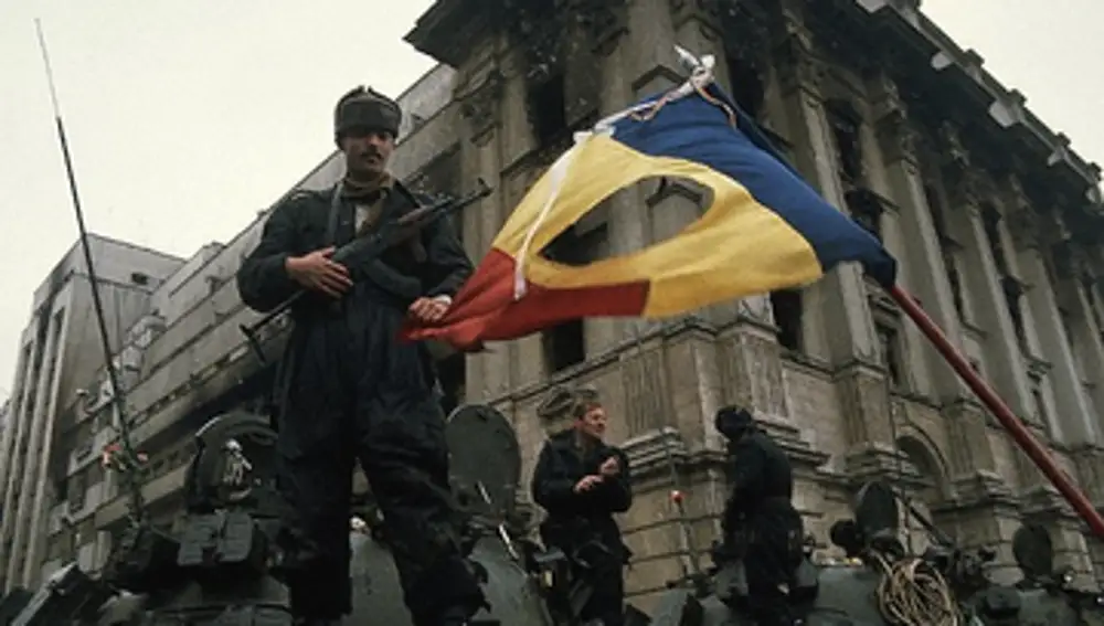 Un soldado con la bandera rumana agujereada durante la revolución que supuso el fin de la República Socialista que controlaba el país