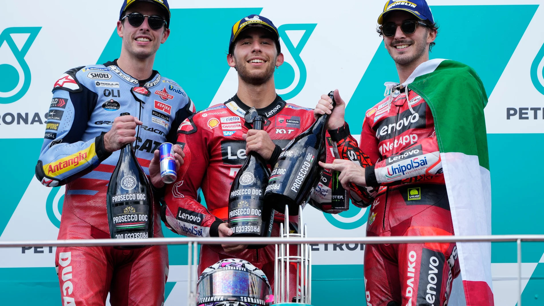 Winner Italian rider Enea Bastianini, center, second-placed Spanish rider Alex Marquez, left, and third-placed Italian rider Francesco Bagnaia pose for photographers on the podium for the MotoGP class race of the MotoGP Malaysian Grand Prix at the Sepang, Malaysia Sunday, Nov. 12, 2023. (AP Photo/Vincent Thian)