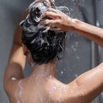 Una joven se enjabona el pelo en la ducha