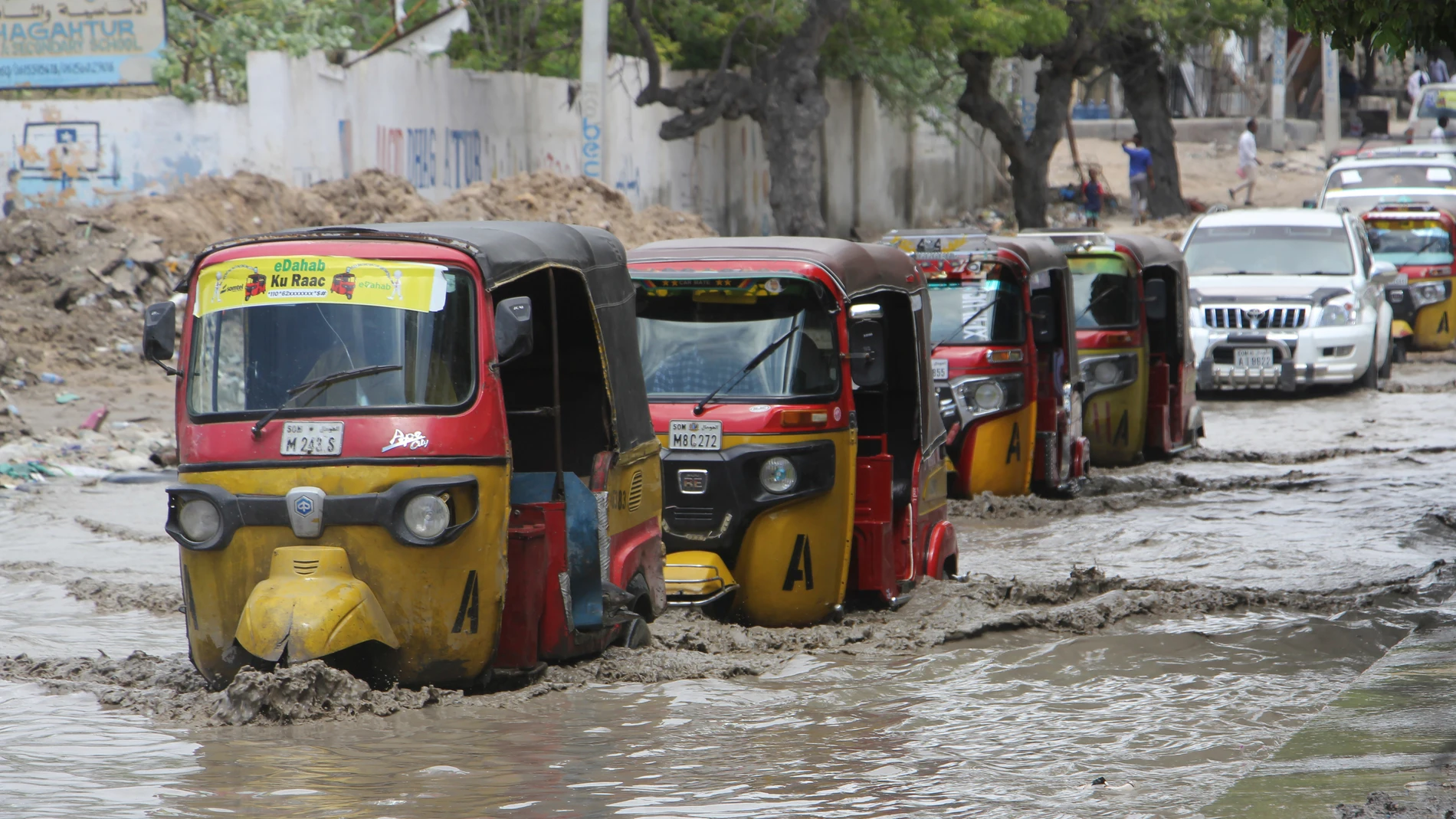 Tuktuks pass through a flooded road after heavy rain in Mogadishu, Somalia, Monday, Nov. 13, 2023. Since October, floods caused by torrential rainfall have displaced nearly half a million people and disrupted the lives of over 1.2 million people, and have caused extensive damage to civilian infrastructure notably in the Gedo region of southern Somalia, officials said. (AP Photo/Farah Abdi Warsameh)