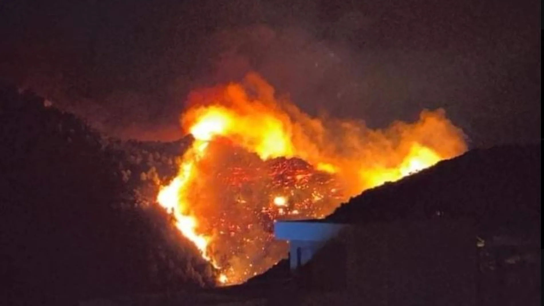 Los bomberos luchan por controlar un incendio forestal en la sierra de Segària (Alicante) avivado por el poniente
