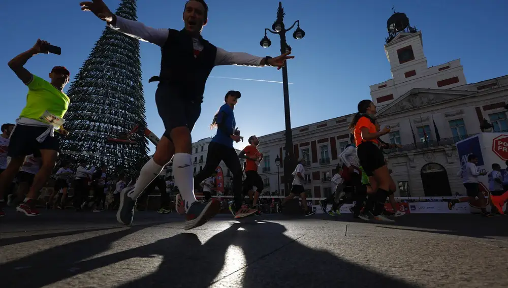 Algunos de los cerca de 18.000 corredores que han participado este domingo en la carrera 'Ponle Freno' a su paso por la Puerta del Sol de Madrid