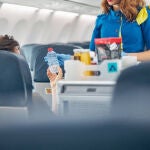 Una azafata ofrece comida en un avión