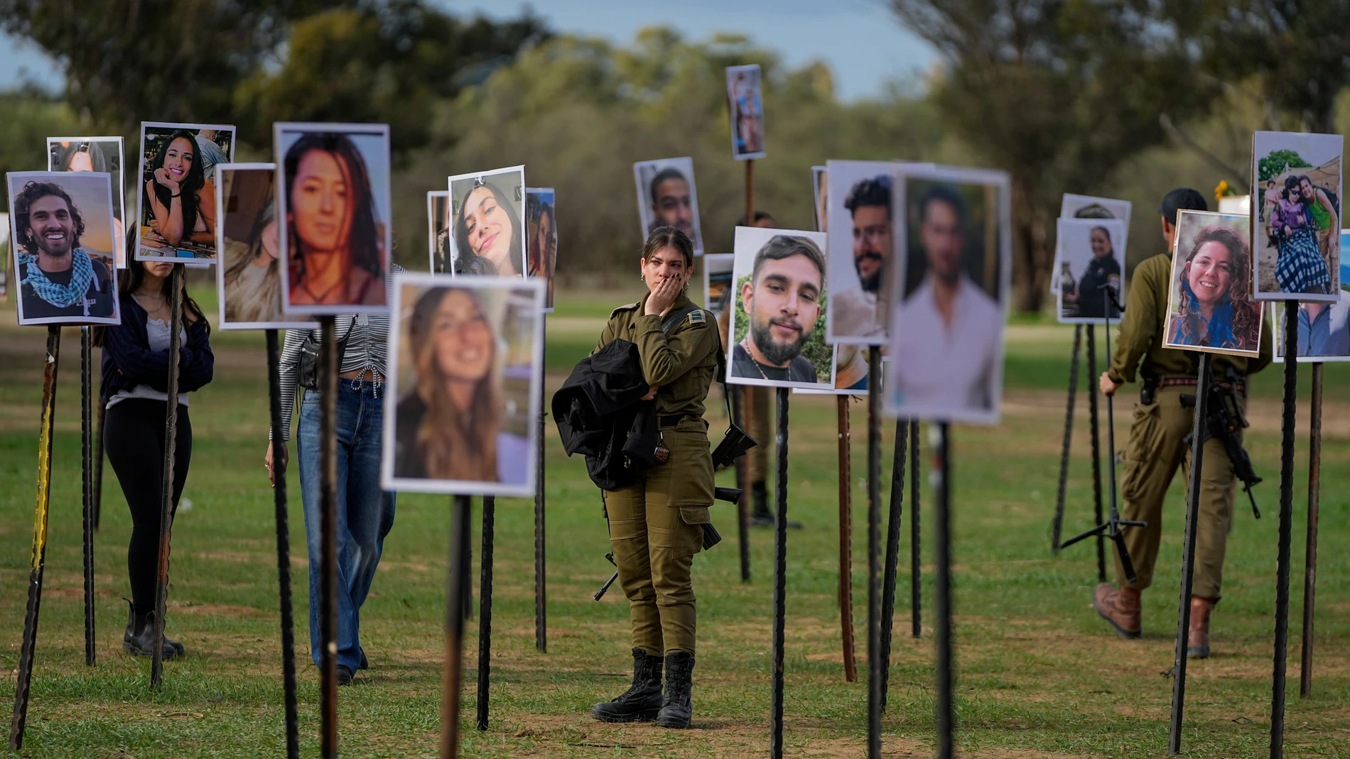 Soldados israelíes entre fotos de civiles asesinados por Hamás
