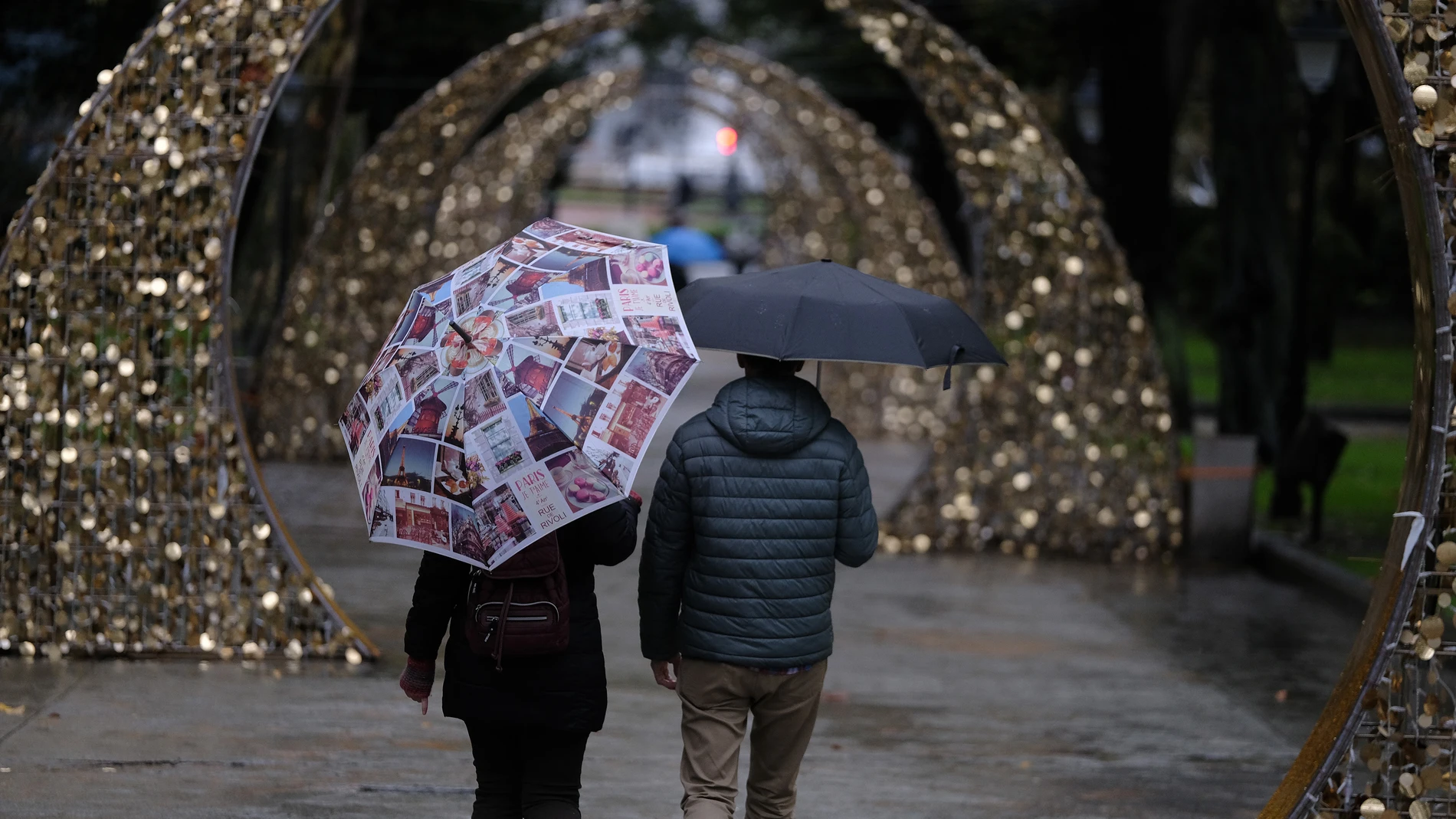 Imagen de archivo de una pareja paseando en Oviedo bajo la lluvia
