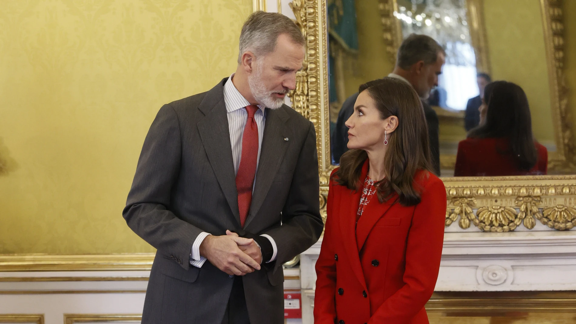 La Reina Letizia con traje rojo junto al Rey Felipe.