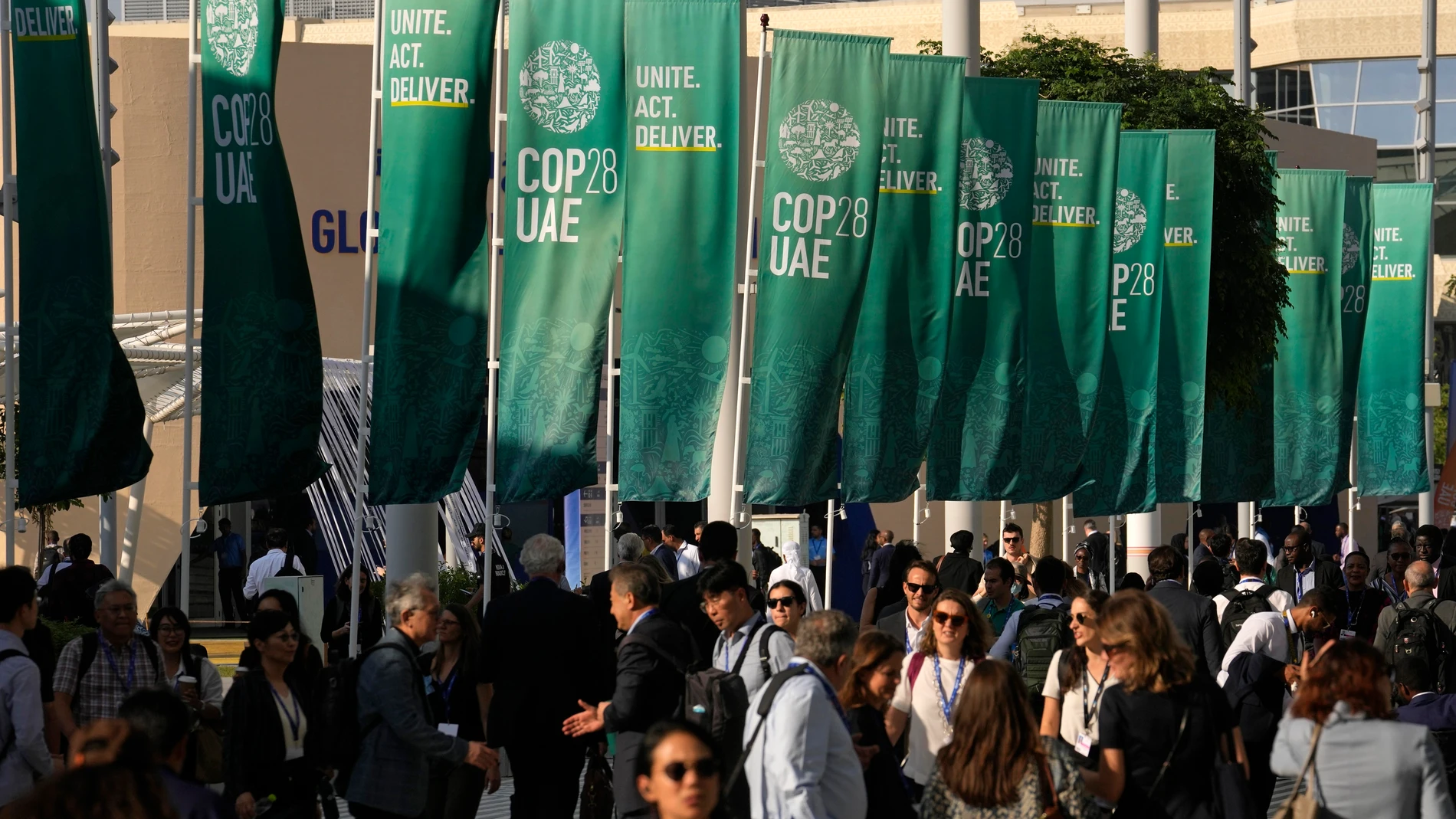 People walk through the COP28 U.N. Climate Summit, Tuesday, Dec. 5, 2023, in Dubai, United Arab Emirates. (AP Photo/Rafiq Maqbool)