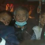 El expresidente peruano Alberto Fujimori, de 85 años, en el centro, es conducido fuera de prisión por sus hijos Keiko y Kenji