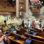Momento en el que dos hombres rocía de gas el parlamento indio