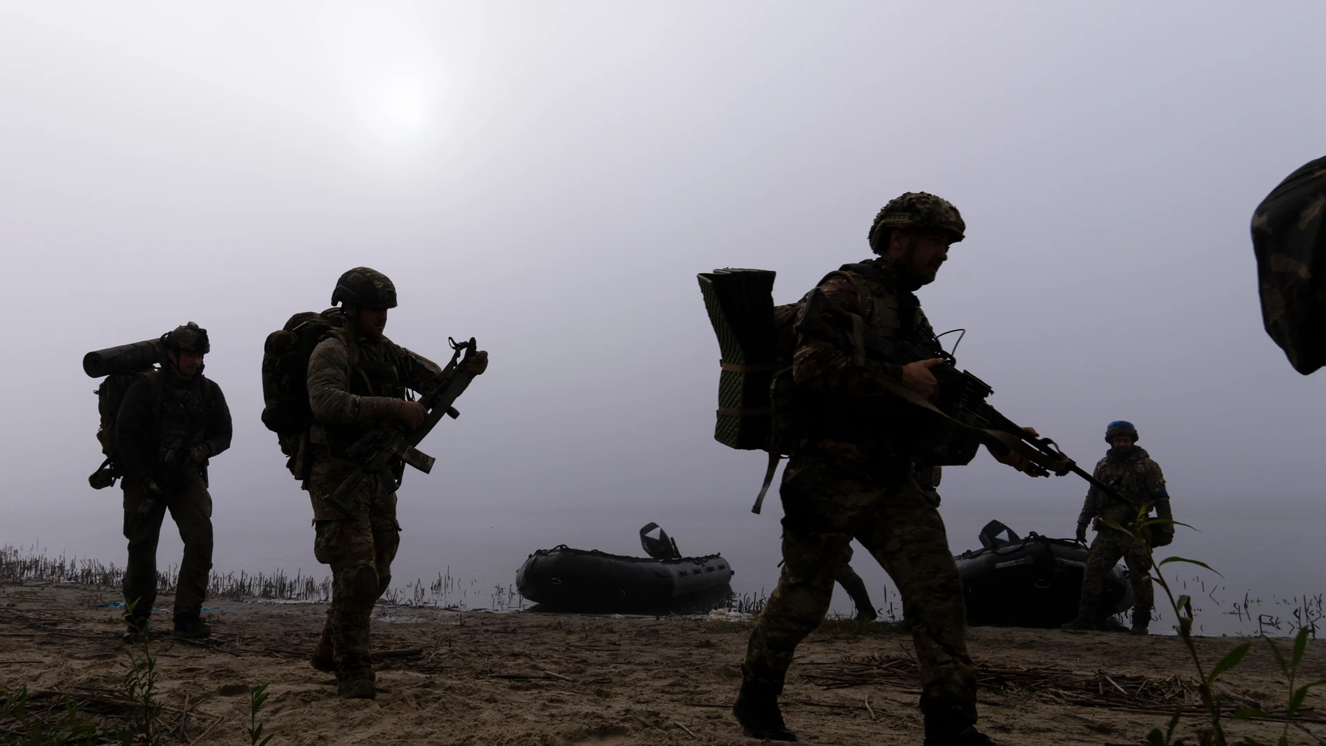 FILE - Ukrainian servicemen walk on the shore of Dnipro river after exiting a boat at the front line near Kherson, Ukraine, Sunday Oct. 15, 2023. A gloomy mood hangs over Ukraine’s soldiers nearly two years after Russia invaded their country. Ukrainian soldiers remain fiercely determined to win, despite a disappointing counteroffensive this summer and signs of wavering financial support from allies. (AP Photo/Mstyslav Chernov, File)