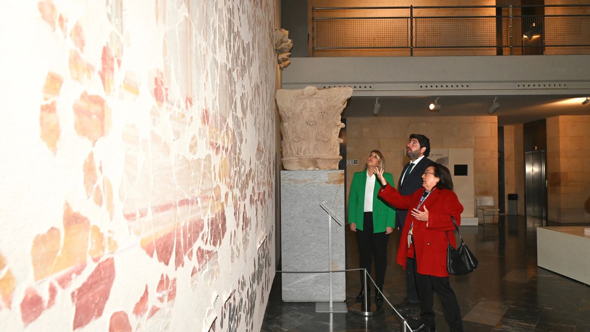 López Miras, la alcaldesa de Cartagena, Noelia Arroyo, y la directora del Teatro Romano de Cartagena, Elena Ruiz Valderas, visitan el mural con las piezas recuperadas del pórtico