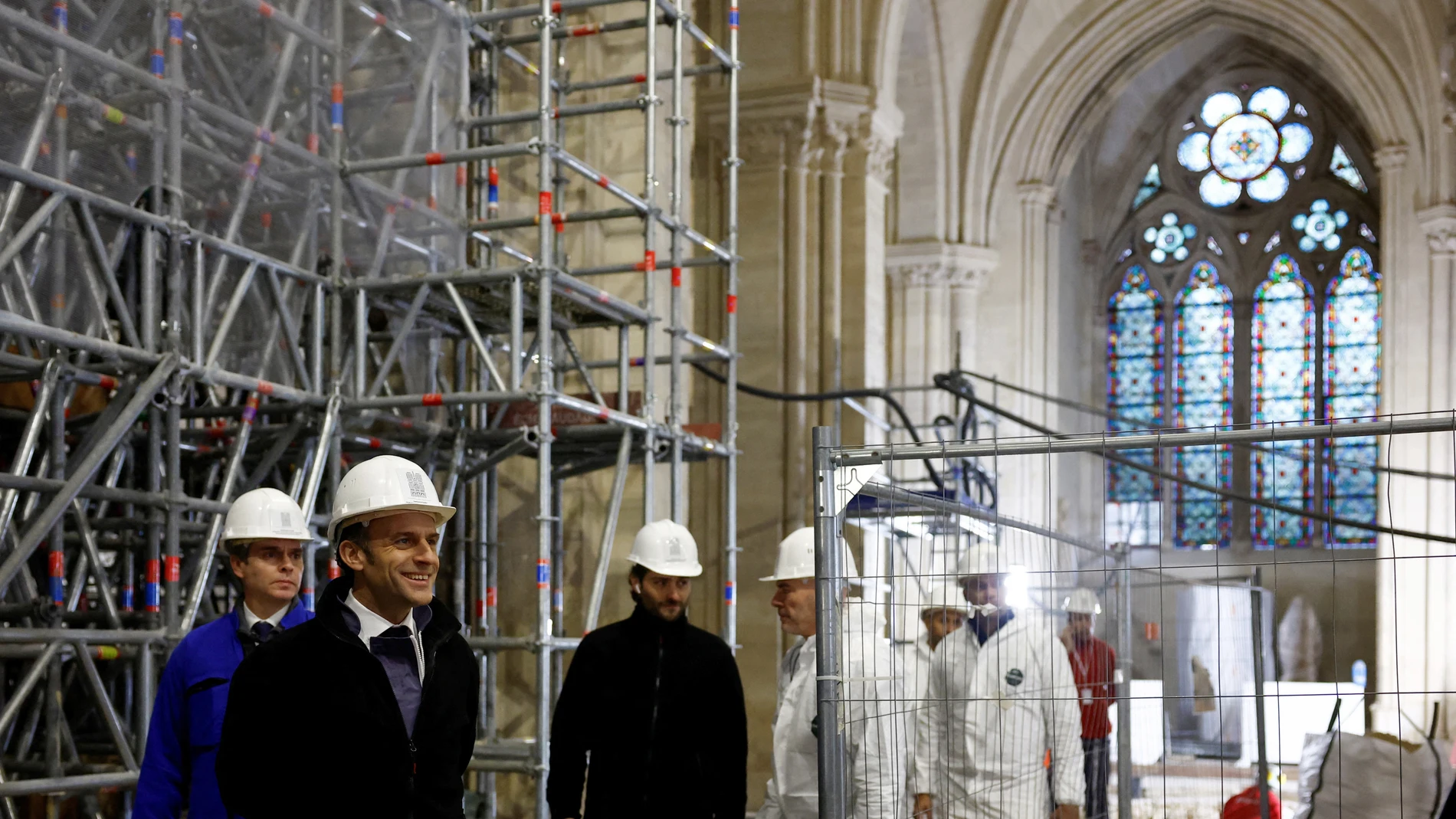 French President Emmanuel Macron (2L) walks inside the nave during a visit of the reconstruction work at the Notre-Dame de Paris Cathedral, on the Ile de la Cite in Paris.