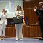 La nueva ministra de Sanidad, Mónica García (c), acompañada de la vicepresidenta segunda Yolanda Díaz (i), recibe su nueva cartera a manos del ex ministro José Miñones, durante la toma de posesión de su cargo, este martes en Madrid.