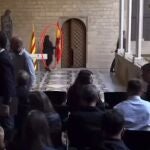 Empleada de la Generalitat retira la bandera de España antes de la comparecencia de Aragonés