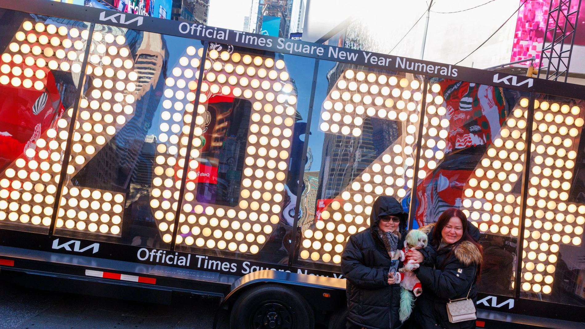 -FOTODELDÍA- EA3877. NUEVA YORK (ESTADOS UNIDOS), 20/12/2023.- Dos personas posan para fotos frente a los números de siete pies de altura '2024', que se colocarán en la cima de One Times Square para la celebración del Año Nuevo, hoy, en Nueva York (EE.UU.). EFE/ Sarah Yenesel 