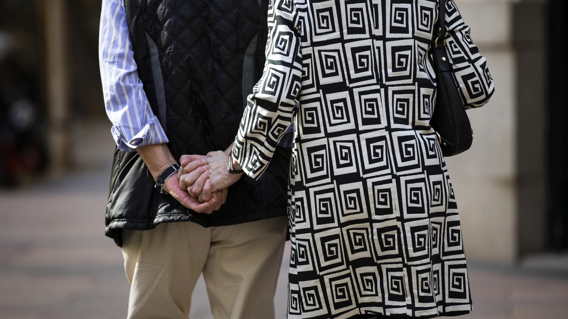 Imagen de una pareja de personas mayores de espaldas cogidos de la mano