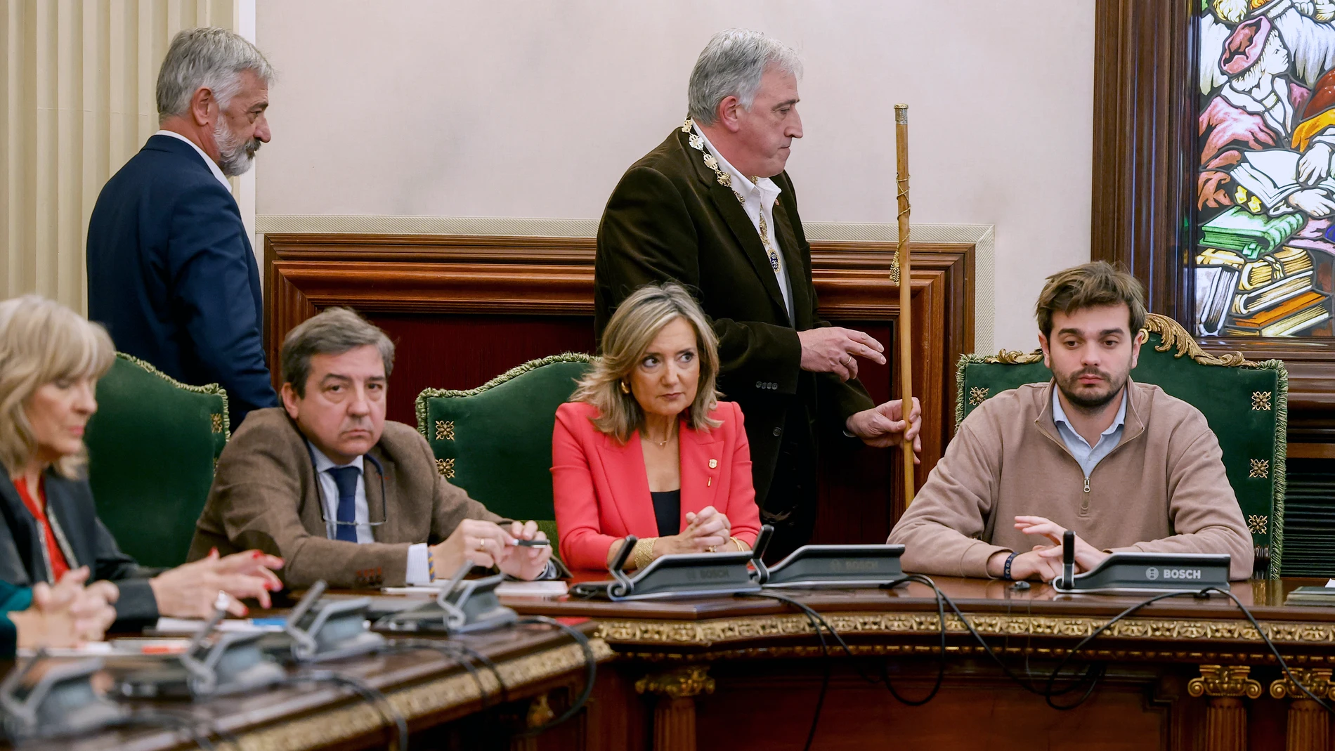 PAMPLONA, 28/12/2023.- El diputado de EH Bildu, Joseba Asiron (c) pasa con el bastón de mando junto a su predecesora en el cargo, Cristina Ibarrola (c-abajo) tras proclamarse alcalde de Pamplona tras la moción de censura en el Ayuntamiento de Pamplona, este jueves. La primera moción de censura de la historia democrática del Ayuntamiento de Pamplona despojará de la alcaldía a UPN y dará paso a un gobierno local liderado por EH Bildu con el apoyo de PSN, Geroa Bai y Contigo-Zurekin. EFE/Villar ...