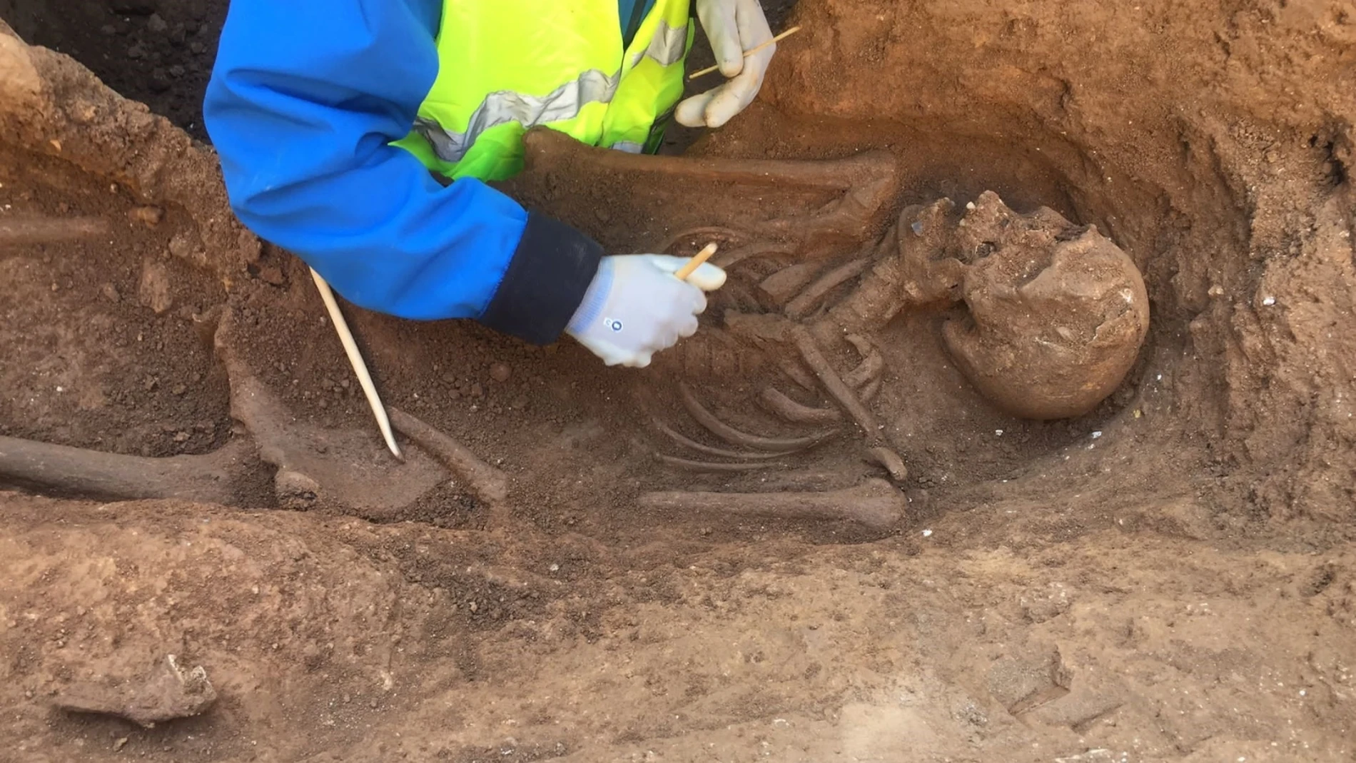 Un arqueólogo trabajando sobre una tumba