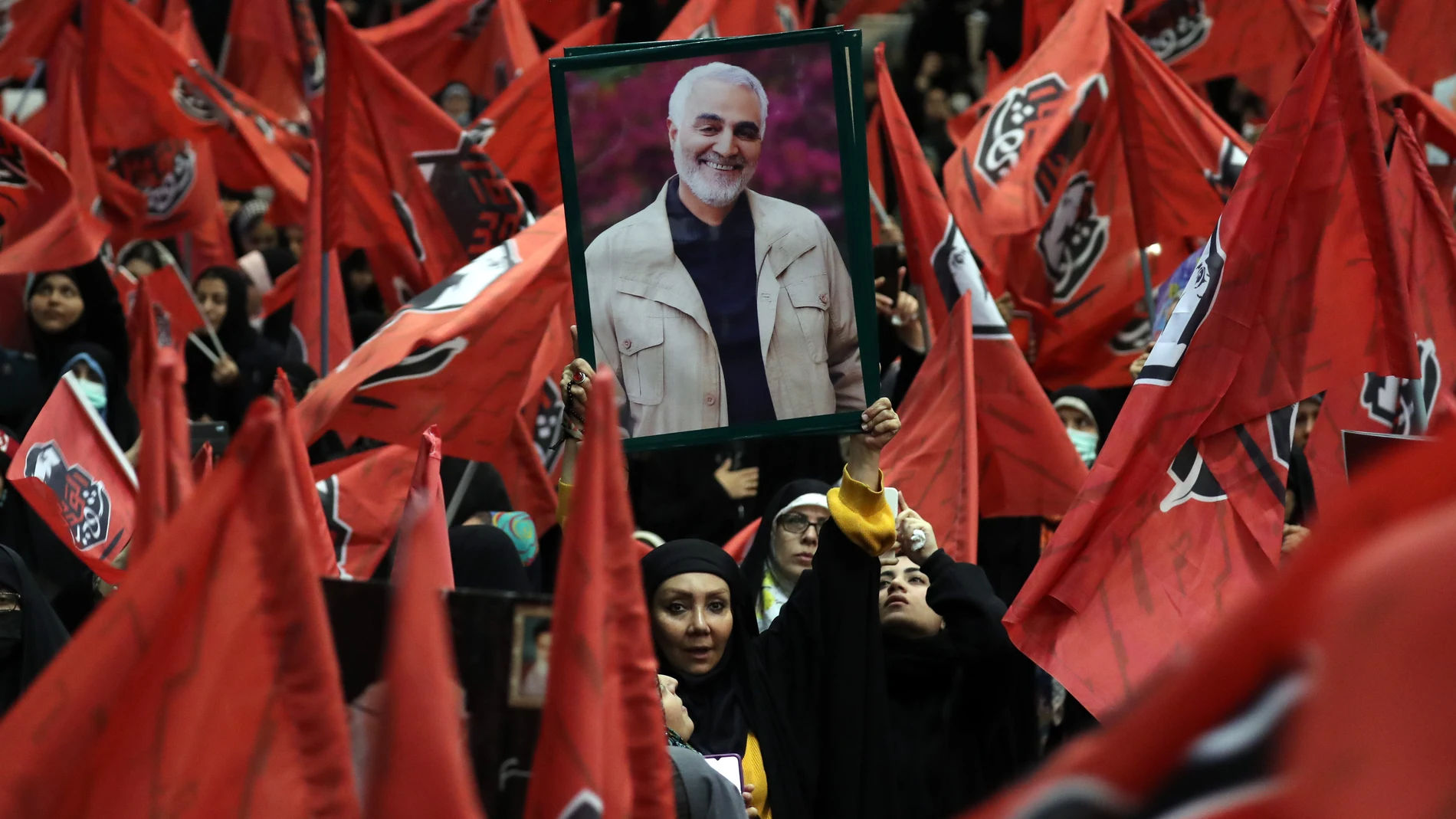 Tehran (Iran(islamic Republic Of)), 03/01/2024.- Iranian's wave images of the late Iran's Islamic Revolutionary Guard Corps (IRGC) Quds Force commander Qasem Soleimani during the fourth anniversary of his death, in Tehran, Iran, 03 January 2024. On the fourth anniversary of the assassination of Iranian General Qasem Soleimani, two explosions have killed at least 103 people and another 171 people were wounded near the mausoleum dedicated to him, according to Iranian state television. As part o...