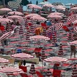 Bañistas buscan refugio del sol en una playa italiana en julio de 2023