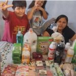 Una familia y los alimentos que han comprado con la ayuda de un donante de Cirineo