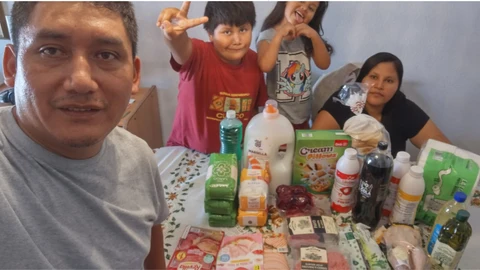 Una familia y los alimentos que han comprado con la ayuda de un donante de Cirineo