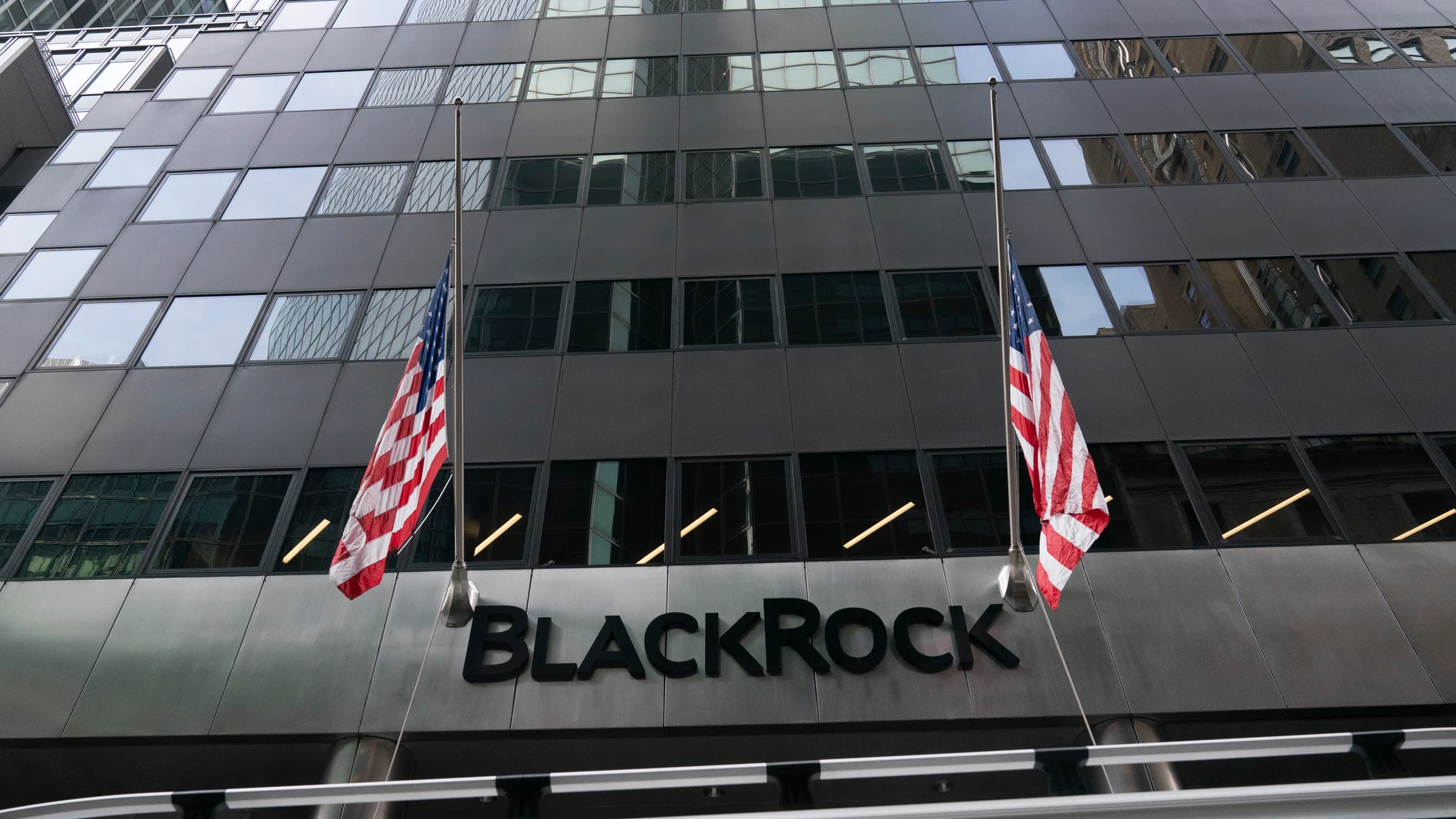 FILE -Flags fly on the front of BlackRock headquarters, Wednesday, Jan. 13, 2021, in New York. Asset manager BlackRock is buying independent infrastructure fund manager Global Infrastructure Partners in a cash-and-stock deal valued at more than $12 billion. The deal announced Friday, Jan. 12, 2024, includes $3 billion in cash and approximately 12 million shares of BlackRock. (AP Photo/Mark Lennihan, File)